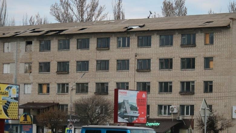 Кусок шифера свисает с крыши здания в центре Никополя 